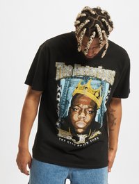 Black cotton t-shirt with a graphic design featuring a portrait of a man wearing a gold crown, surrounded by text and cityscape elements.