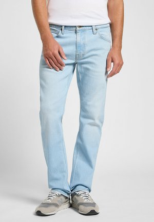 Ljusa blå denimjeans med rak benklippning, med en klassisk femficksdesign och subtilt blekt mönster. Bärs med grå sneakers.