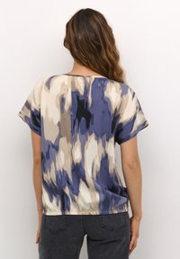 Short-sleeve top in lightweight fabric featuring a blue and cream abstract print. Loose fit with a round neckline and smooth texture.