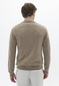 Suéter beige de pullover con mangas largas, puños y dobladillo acanalados; hecho de material suave; textura sencilla y lisa sin patrones.