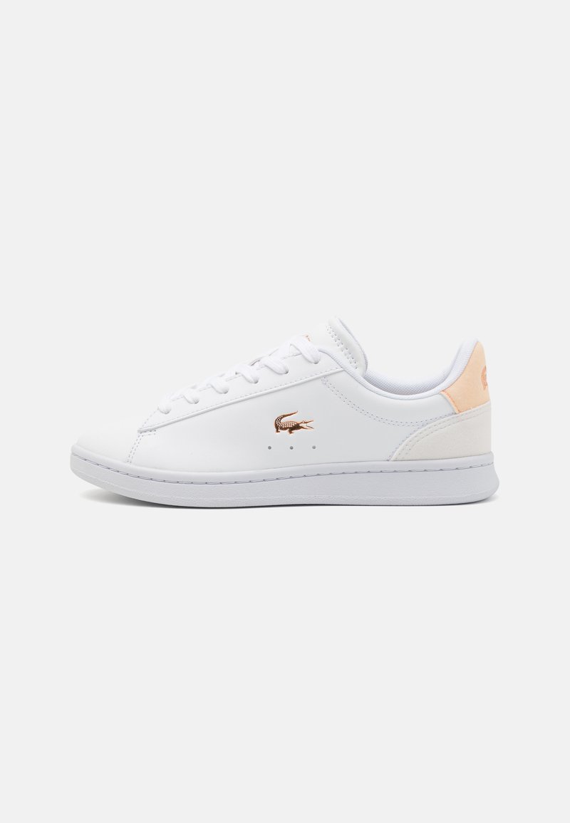 Fehér sneaker sima bőr felsőrésszel, kerek orral és fűzős rögzítéssel. Finom rózsaszín részlet található a saroknál és egy fényes logó.