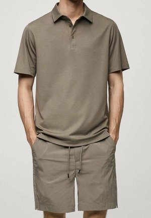 Khaki polo-shirt med korte ærmer og tre knapper, parret med matchende shorts med elastisk talje og sidelommer.