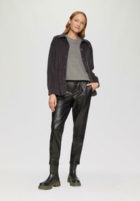 Donker corduroy overhemdjack, grijze ribbeltrui, zwarte leren broek, zwarte laarzen met dikke zolen, minimalistisch ontwerp, gladde textuur.