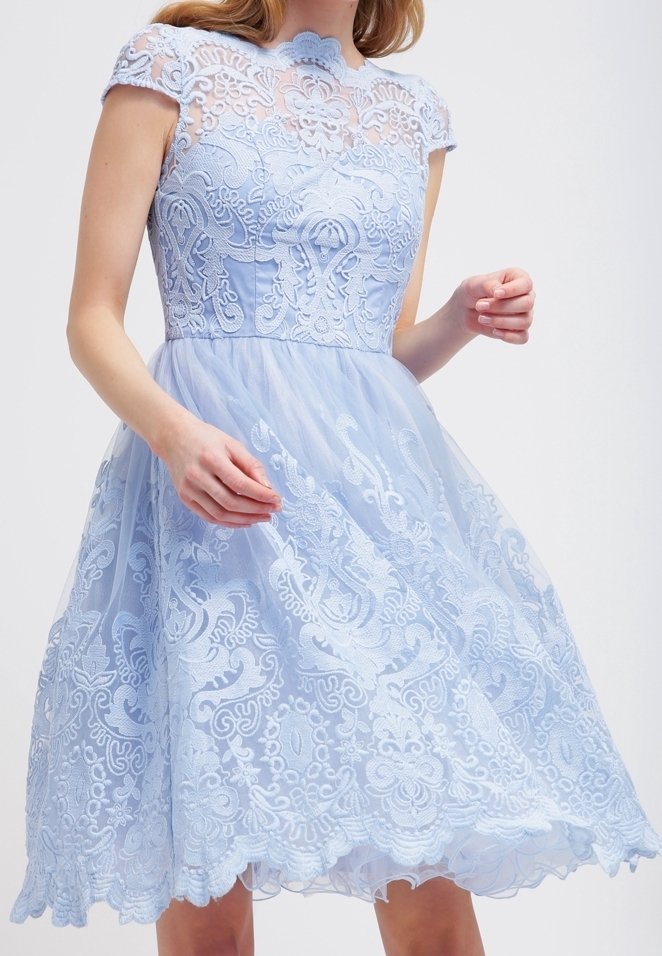 Ljusblå klänning med en figurnära spetsliv, korta ärmar och en svävande tyllkjol. Invecklade blomsterbroderidetaljer och scalloped nederkant.