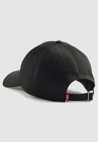 Gorra de algodón negro con visera curva. Correa ajustable en la parte trasera con hebilla de metal. Presenta detalles cosidos y ojetes de ventilación.