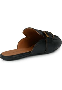 Scarpa in pelle nera scivolata con retro aperto, punta arrotondata, superficie liscia e dettaglio in fibbia sulla cinghia. Sottopiede marrone visibile.