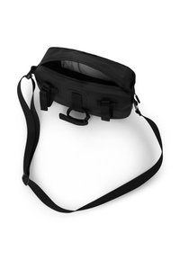 Czarna torba na ramię z zamkiem błyskawicznym na górze, regulowanym paskiem i wieloma zewnętrznymi paskami. Gładki materiał i przestronna wewnętrzna komora.