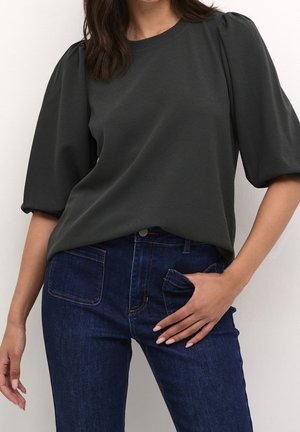 Ciemnoszara krótkorękawowa bluzka z okrągłym dekoltem i bufkami na rękawach, zestawiona z niebieskimi jeansami z kieszeniami z przodu i z tyłu.