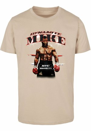 Camiseta de algodón beige con un estampado gráfico de un boxeador que lleva el texto "DYNAMITE MIKE", acentos rojos y guantes negros.