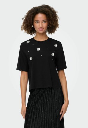 Zwarte T-shirt met korte mouwen en een ronde halslijn, versierd met zilveren bloemen en kralen op de voorkant. Gladde katoenen stof.