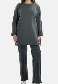 Gråt træningssæt med langærmet tunika-top med rund halsudskæring og matchende stribede bukser. Blødt, tekstureret stof.