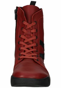 Botas de cuero rojo con cordones y acentos laterales negros, que cuentan con una cremallera en el costado exterior y suelas de goma texturizadas.