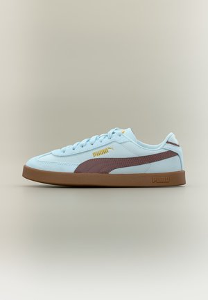 Φωτεινό μπλε αθλητικό Puma με καφέ ρίγα και σόλα, χρυσό λογότυπο Puma στο πλάι και σχέδιο με κορδόνια σε ουδέτερο φόντο.