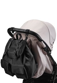 Svart skötväska fäst vid en barnvagnshandtag, med justerbara remmar, klaffstängning och två framfickor. Barnvagnen har ett ljusbeige tak.