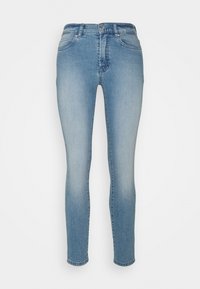 Jeans ajustados de mezclilla azul claro, con zonas desgastadas, diseño de cinco bolsillos y cierre de cremallera con un solo botón en la parte superior.