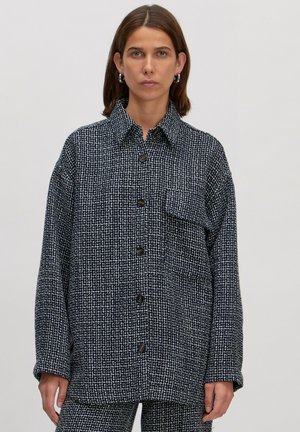 Marineblauwe en witte geblokte oversized overhemdjas met een kraag, frontsluiting met knopen en een enkele borstzak. Geweven stof.
