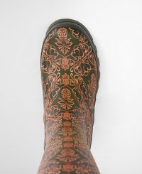 Green waterproof boot with an intricate copper floral pattern, featuring a textured surface and a low rubber sole.