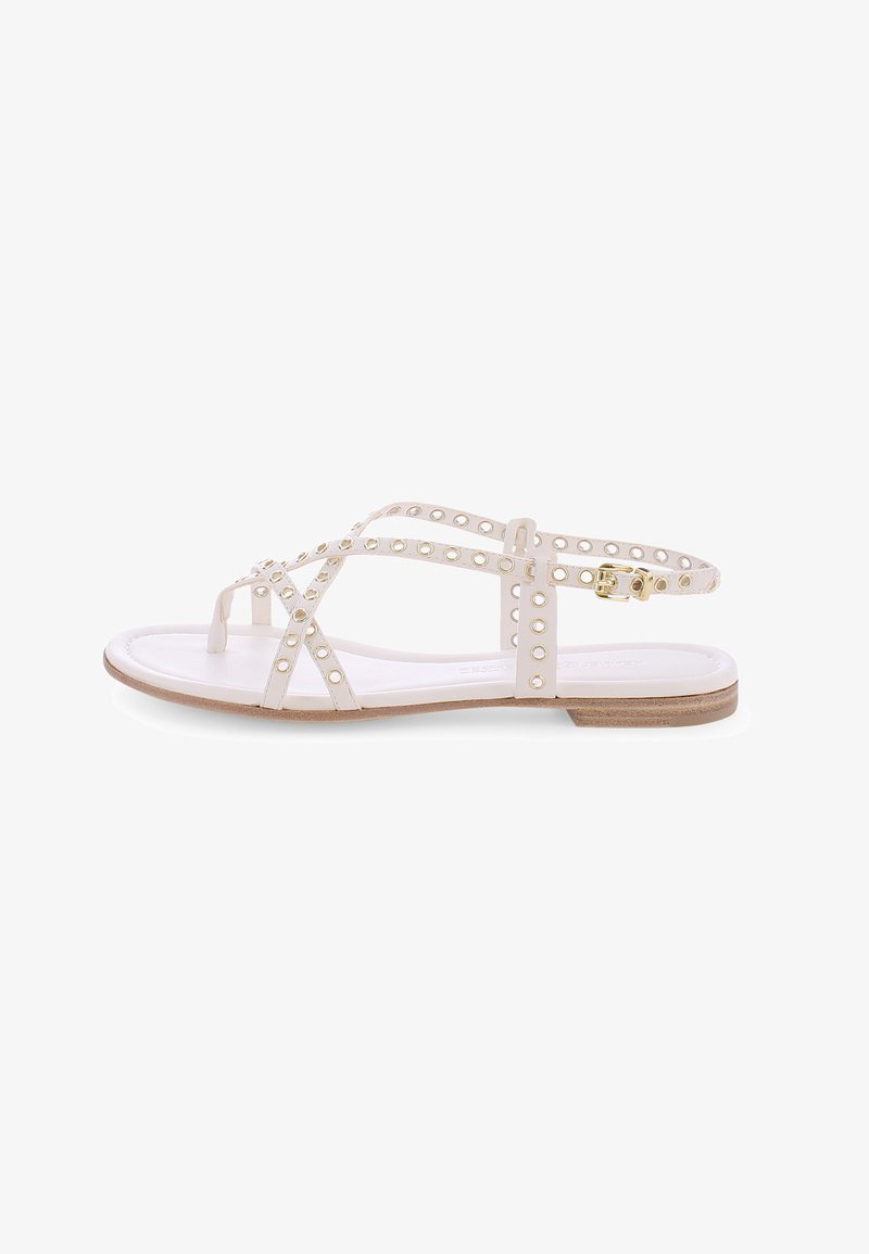 Witte sandalen met een platte zool, voorzien van meerdere gekruiste banden met ronde uitsparingen en gouden hardware accenten. Lichte bruine gestructureerde loopzool.
