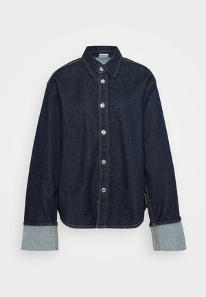 Camisa de ganga azul-escura com colarinho pontiagudo, botões prateados e punhos em azul-claro contrastantes. Apresenta um corte descontraído e fendas laterais.