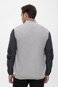 Graue Texturweste mit geripptem Kragen, getragen über einem dunklen Langarmshirt. Verfügt über schwarze Ellbogenpatches und ein figurnahes Design.
