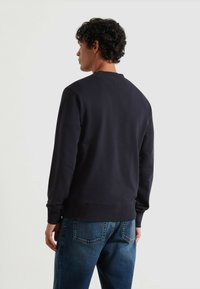 Navyblauwe sweatshirt met ronde hals, ribgebreide mouwen en onderrand. Zacht katoenen materiaal. Draag het met lichte spijkerbroek met achterzakken.