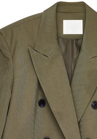 Õlgadest kahepoolsest bleiserist oliiviroheline kangas. Omab laiu krae, musti nuppe ja sile sisemine vooder. Tekstureeritud pind.