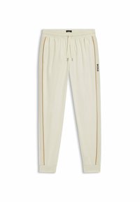Crème-kleurige joggingsbroek met een trekkoord in de taille, taps toelopende pijpen, contrasterende gouden zijstrepen en een zwart logo op het linkerpijp.