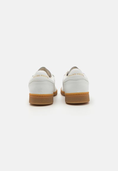 Hvite skinnsko med en jevn tekstur, med såle av lett brunt gummi. Gull "Filling Pieces" merkingen på hælen. Enkelt design.
