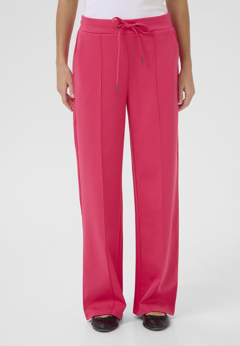 Pantalons en tissu rose vif avec une coupe décontractée, taille à cordon de serrage et poches latérales, comportant des détails de plis sur le devant.