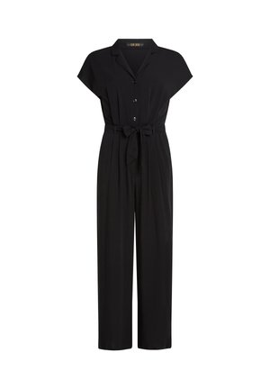 Tuta corta nera con maniche corte, colletto a reversal, bottoni sul davanti, cintura annodata in vita e pantaloni a gamba larga su sfondo bianco.