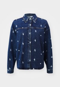 Camisa de denim azul-escuro com gola, apresentando bordados florais brancos, fecho com botões e mangas longas.