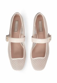 Paire de ballerines Mary Jane en mesh beige avec bouts carrés et brides ajustables à boucles dorées, vues de dessus sur fond blanc.