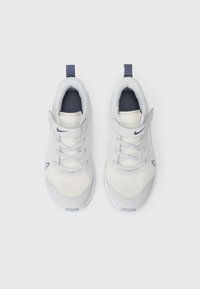 Białe siatkowe sneakersy z granatowymi akcentami. Okrągły czubek, sznurowana konstrukcja i rzep. Gumowa podeszwa z minimalnym wzorem bieżnika.