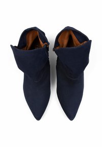 Bottines en daim bleu marine à bout pointu, avec un revers et doublure en cuir marron. Texture lisse, design minimaliste.