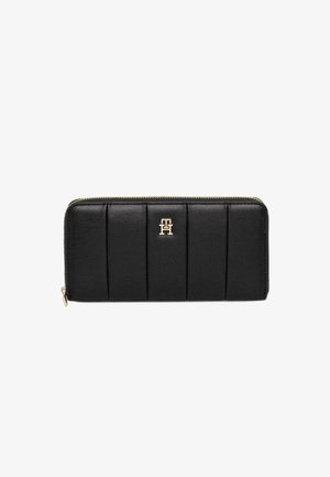 Black leather wallet with a vertical quilted design, gold hardware, and a logo accent in the center. Features a zip closure.