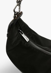 Borsa a mano nera in pelle con forma arrotondata, caratterizzata da una zip e accessori in argento. Marchio ben visibile sul cursore della zip. Texture liscia.
