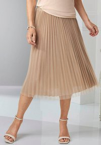Plissé midi rok in lichtbeige met een doorschijnende textuur. Beschikt over een aansluitende tailleband en gelaagd stof voor beweging. Draagt het met enkelband sandalen.