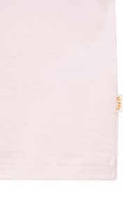 Section de tissu rose clair avec une petite étiquette blanche et jaune sur le bord droit portant la mention « BIK BOK ».