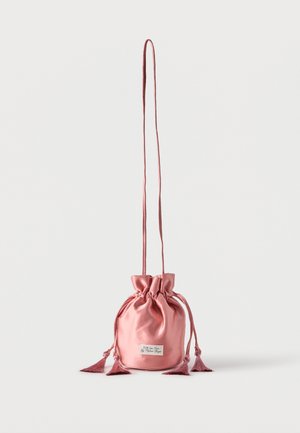 Pink satin drawstring pouch bag with long strap and tassel details, standing upright on a plain white background.
