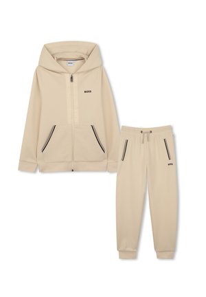 Sweat à capuche zippé beige BOSS avec poches avant et pantalon de jogging assorti avec cordon de serrage, les deux présentant des détails de fermeture éclair noir et blanc.