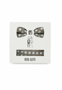 Brown and blue patterned bow tie with matching pocket square in packaging, featuring illustrations and the text "REAL GUYS."
