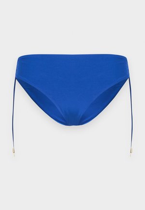 Bas de bikini bleu avec liens latéraux ajustables dotés de petites embouts métalliques dorés, présenté sur un fond clair uni.
