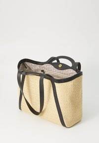 Strohtasche mit schwarzen Ledergriffen. Das Innere verfügt über ein gemustertes Futter mit einem Reißverschlussfach. Offenes Top-Design, rechteckige Form.