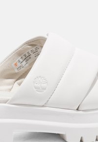 Witte synthetische slide-sandalen met een breed bandontwerp, een getextureerde voetbed en een reliëflogo. Glad afwerking met een minimalistische uitstraling.