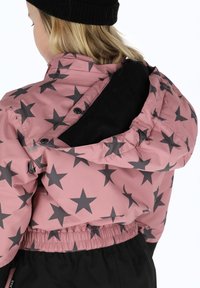 Roze jasje met zwart sterrenpatroon, capuchon, drukknoopsluiting en elastische tailleband. Materiaal lijkt glanzend met een gladde textuur.