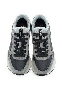 Sneakers grigi con una combinazione di materiali lisci e texture, lacci neri, interno imbottito e etichetta con logo sulla linguetta.