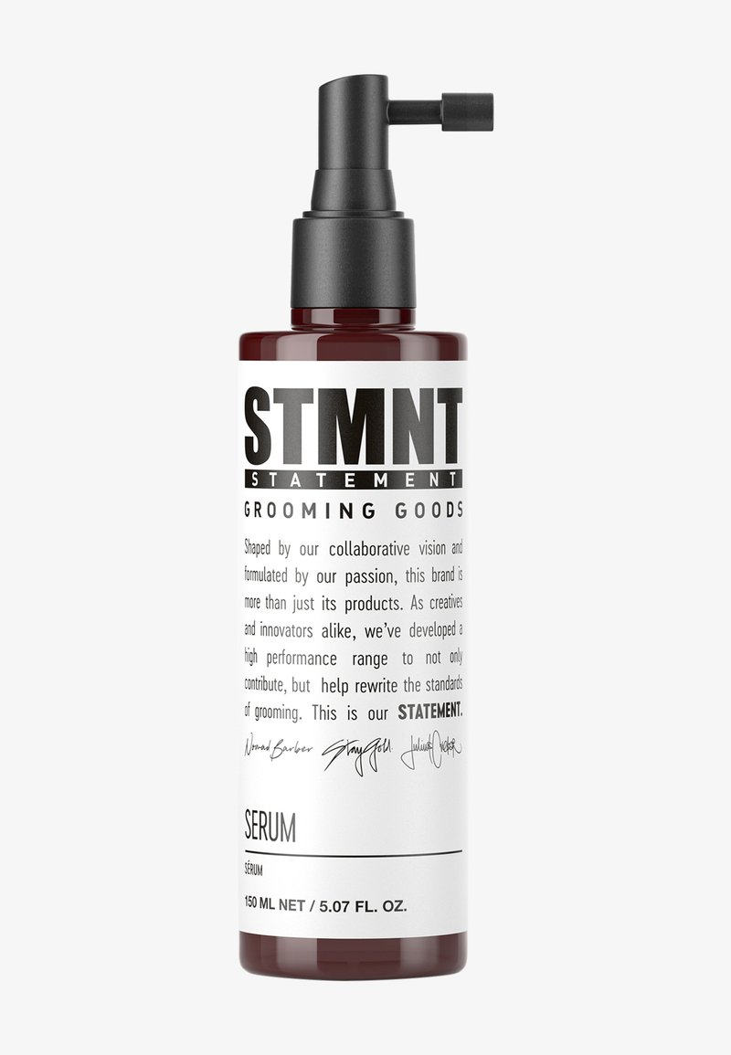 Bärnstensfärgad flaska med svart pumpdispensör. Fetstilad text på etiketten lyder "STMNT GROOMING GOODS" med "SERUM" under. Ren, modern design.