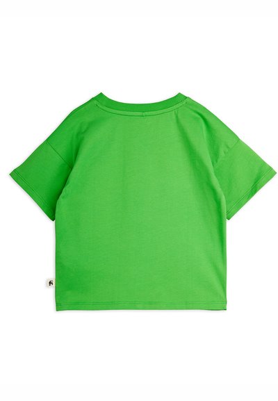 Φωτεινό πράσινο T-shirt με κοντά μανίκια, φαρδιά γραμμή και μικρή λευκή ετικέτα στο κάτω αριστερό μέρος, πάνω σε λευκό φόντο.