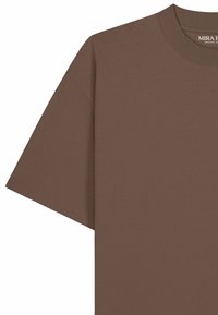 T-shirt marron à manches courtes et col rond avec coutures tombantes aux épaules, en coton biologique.