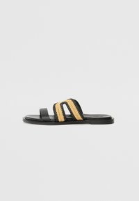 Svart slidesandal med to kraftige vevde striper i beige og svart. Jevn tekstur med flat såle og minimalistisk design.
